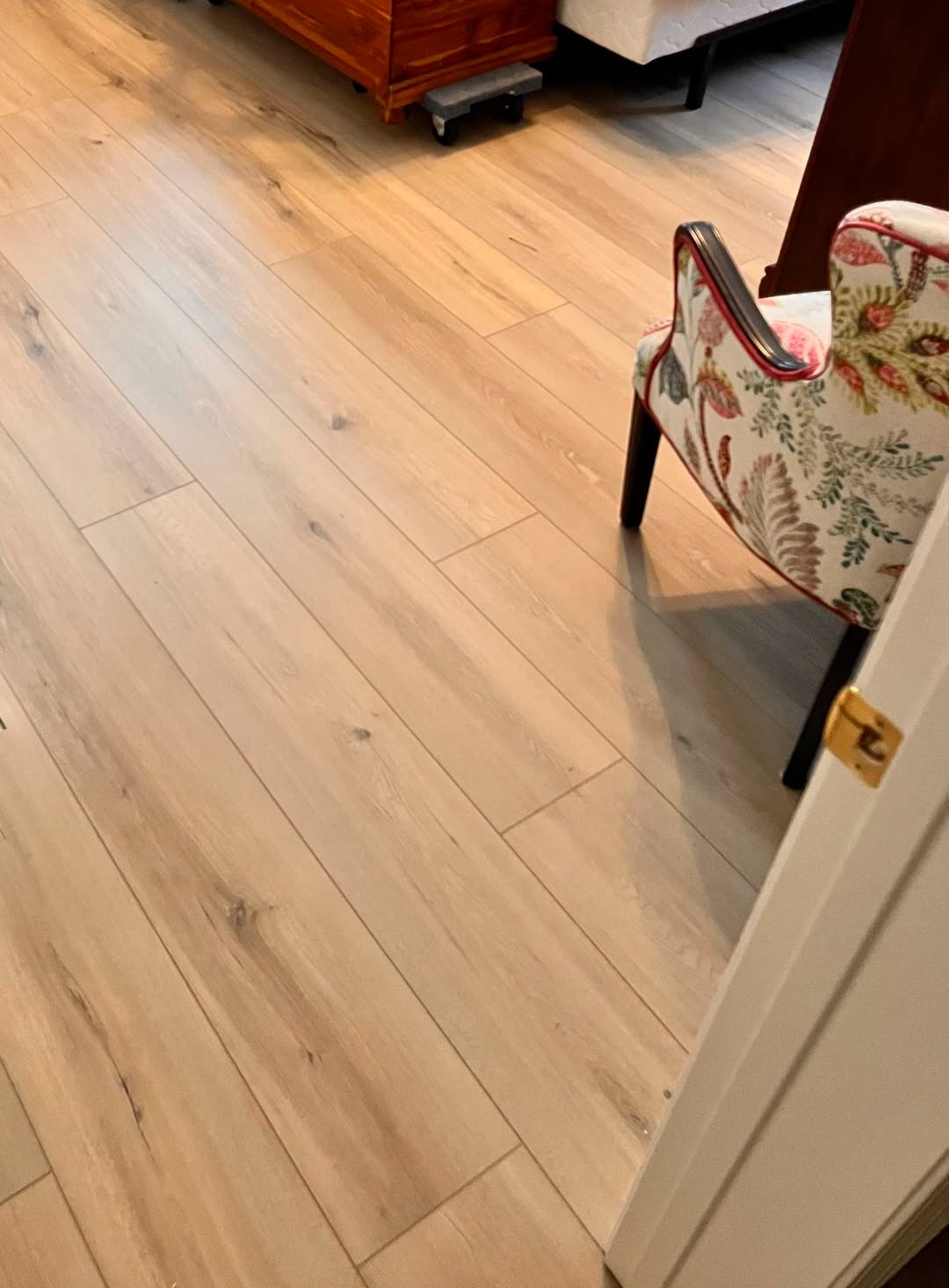 Light wood-tone hardwood flooring in a bedroom.