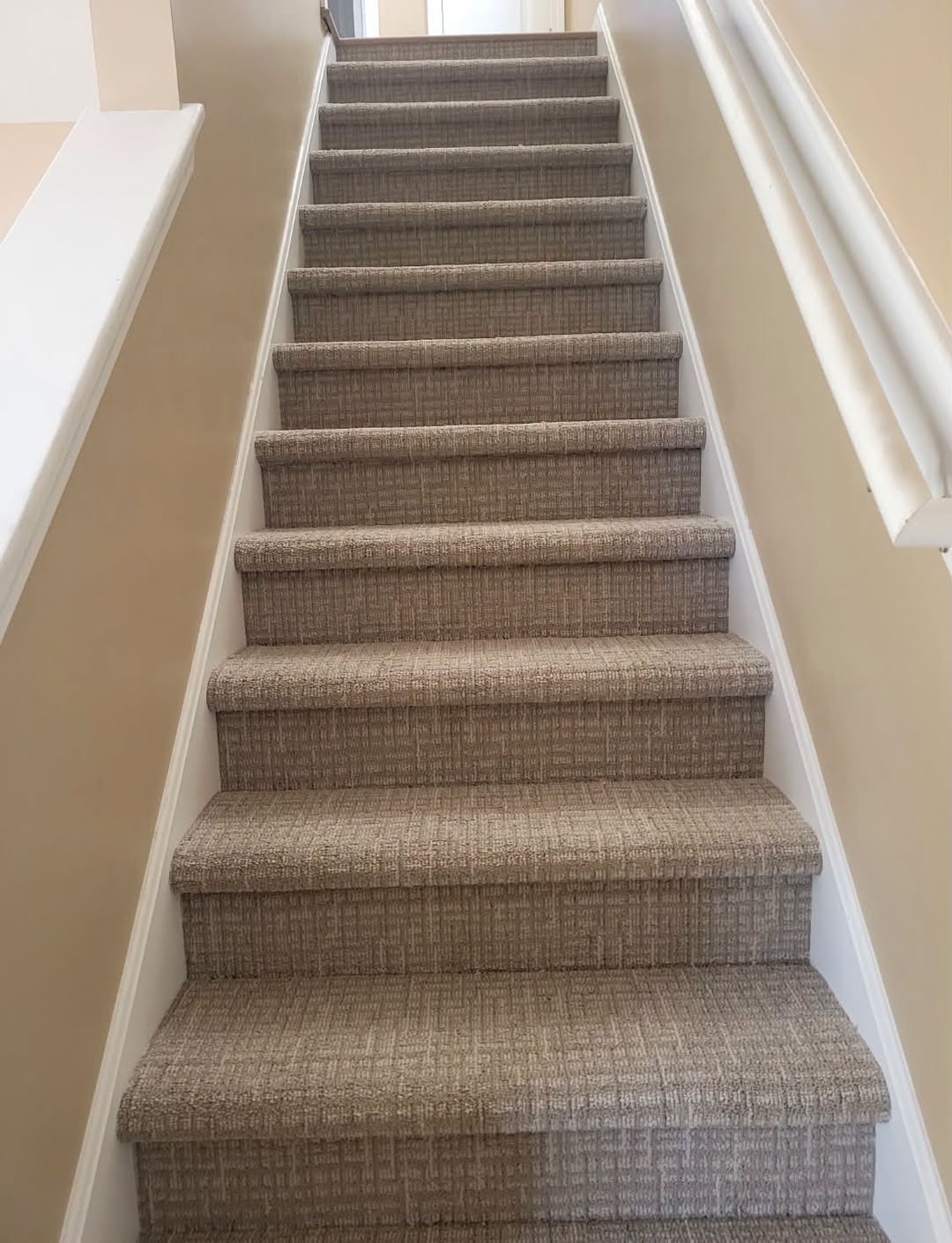 Textured taupe carpet on a staircase.