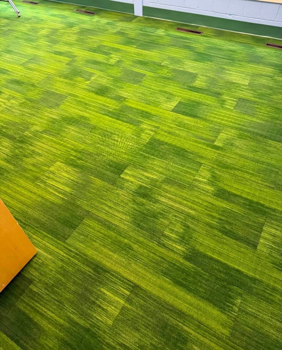 Green patterned carpet tile in a commercial space.