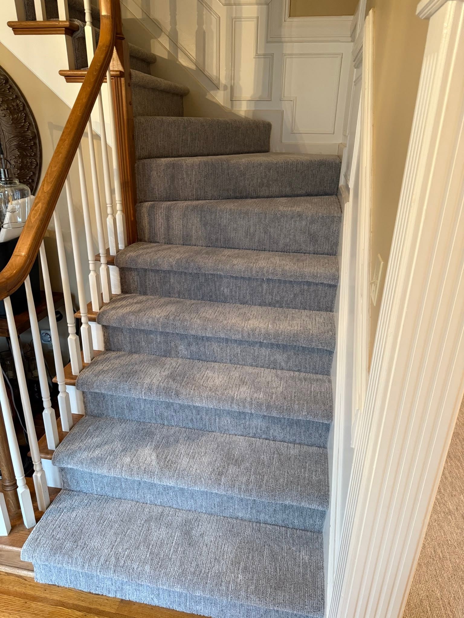 An elegant gray carpet stair runner on a formal staircase.