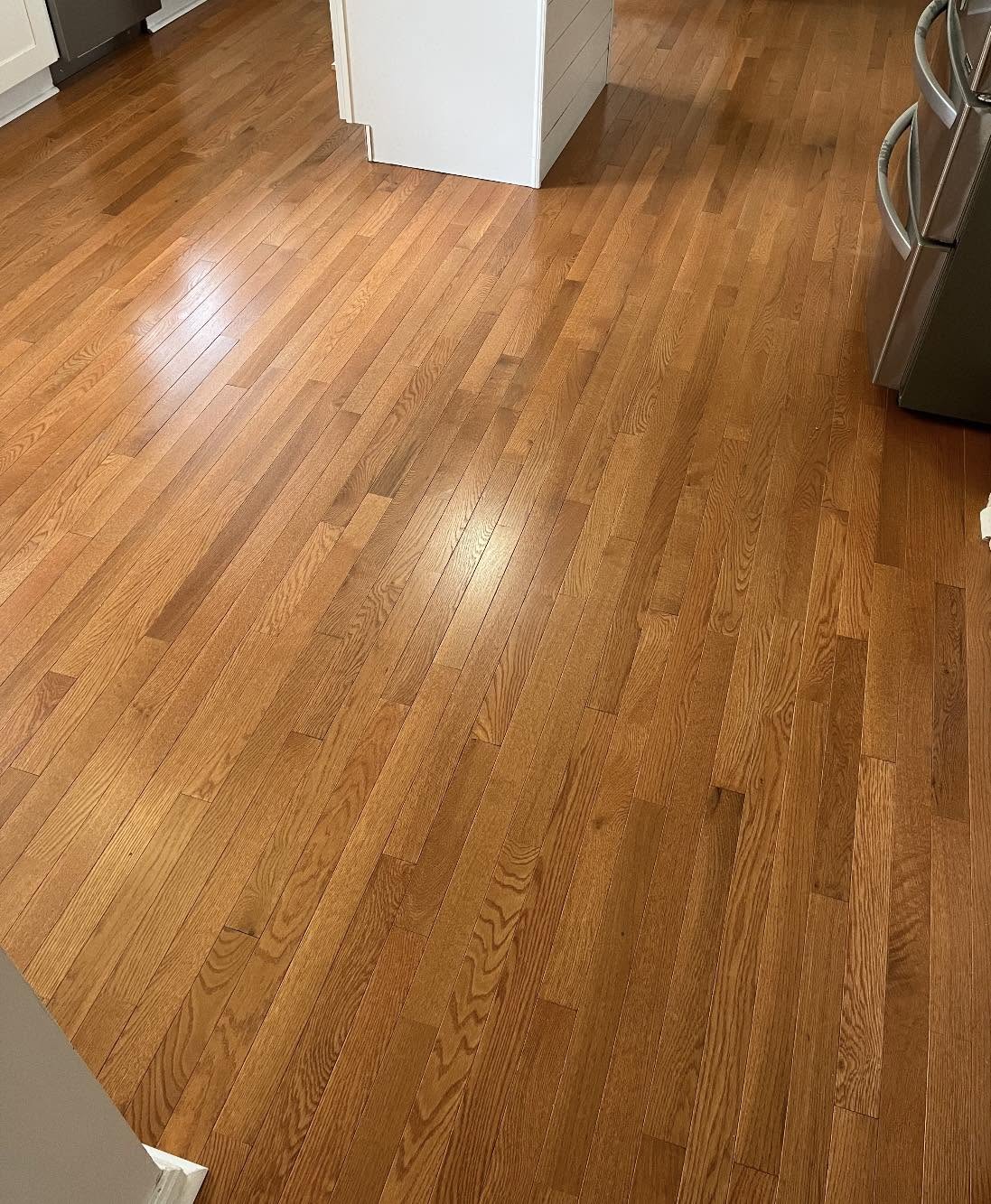 Golden-toned oak hardwood flooring in a kitchen.