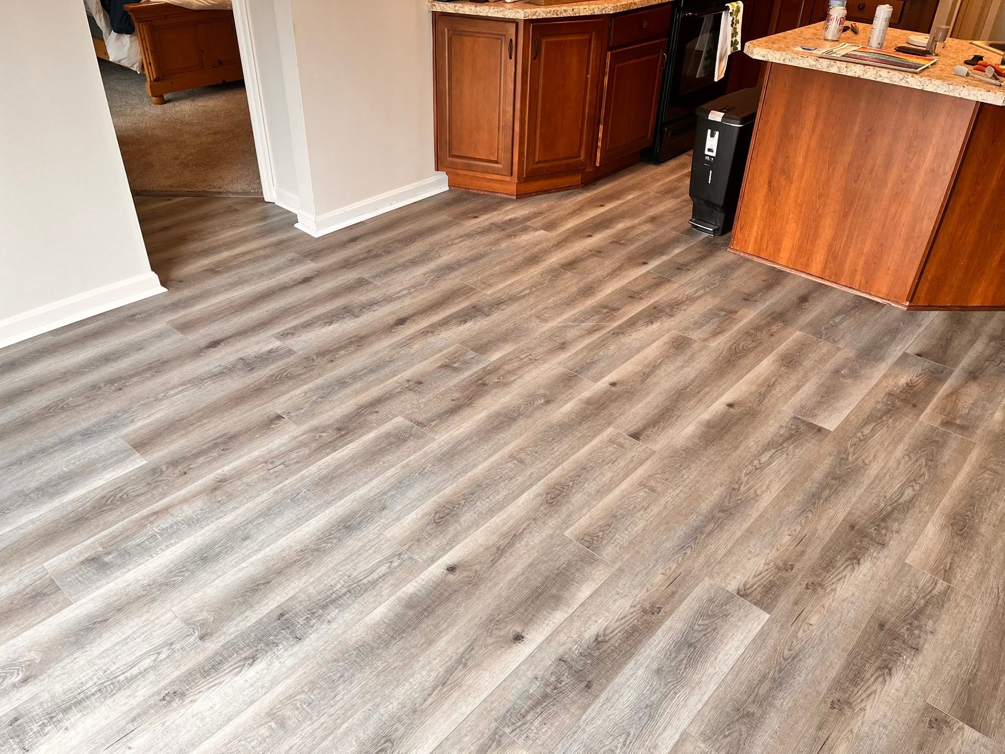 Gray wood-look flooring in a kitchen and dining area.