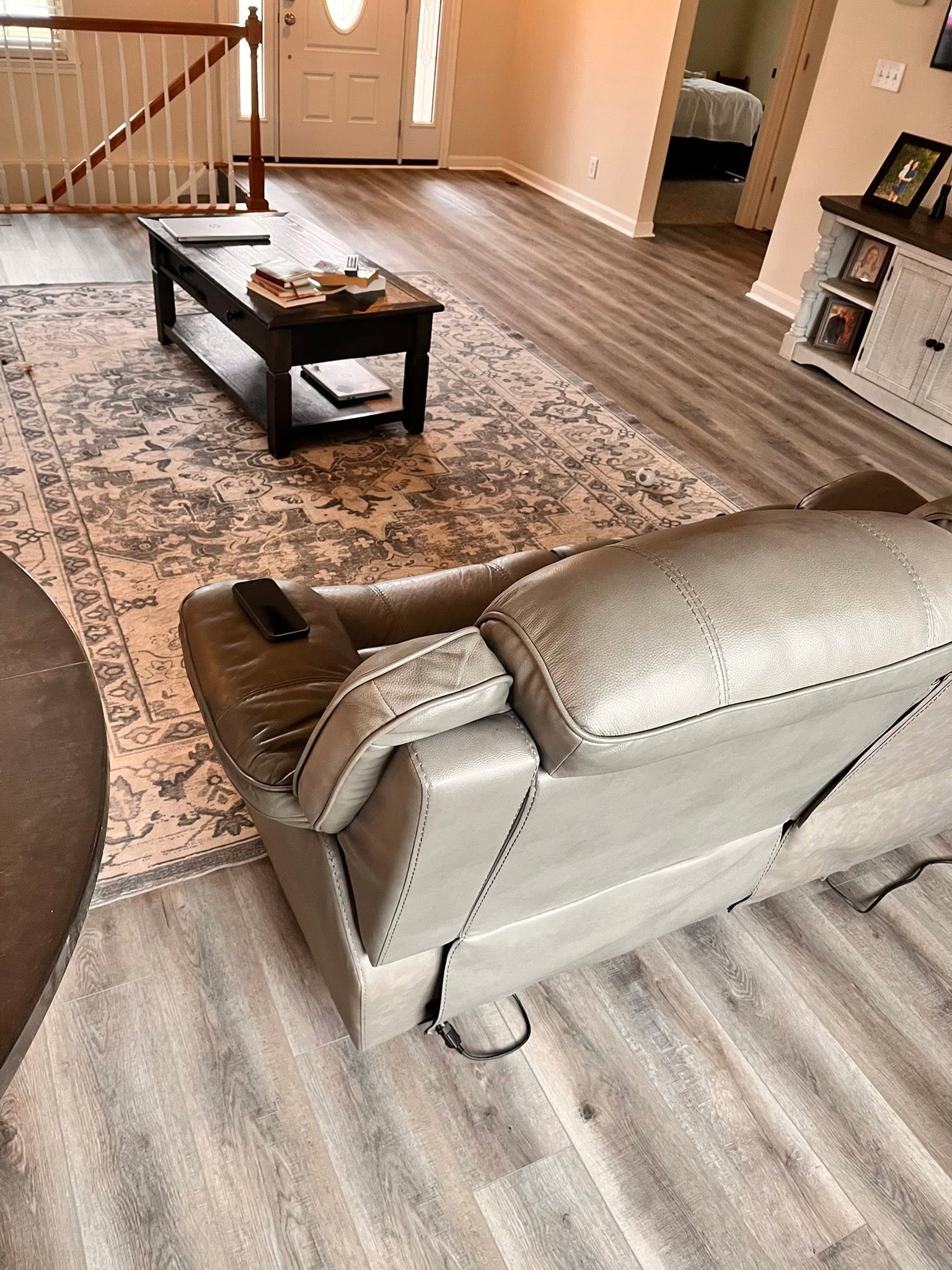 Gray wood-look flooring in a living room with an area rug and a recliner.