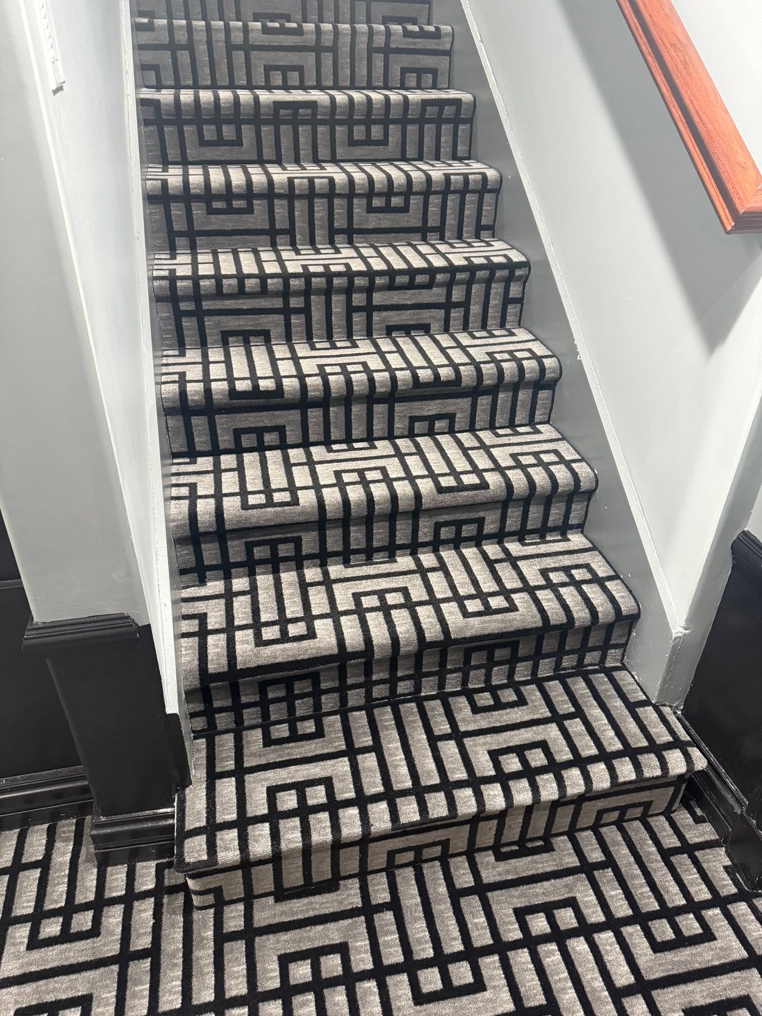 Charcoal and gray geometric-patterned stair carpet.