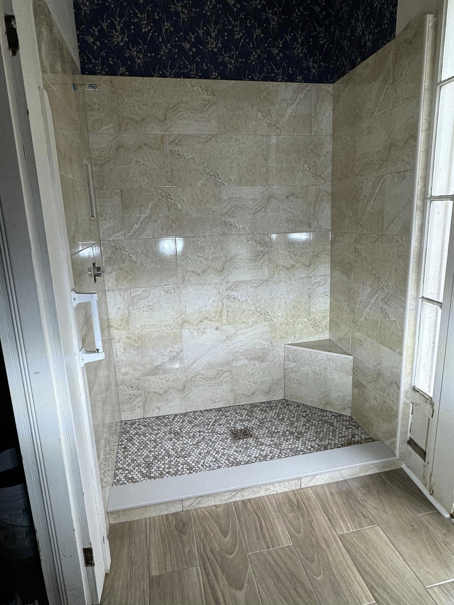 A warm tan travertine-look tile shower.