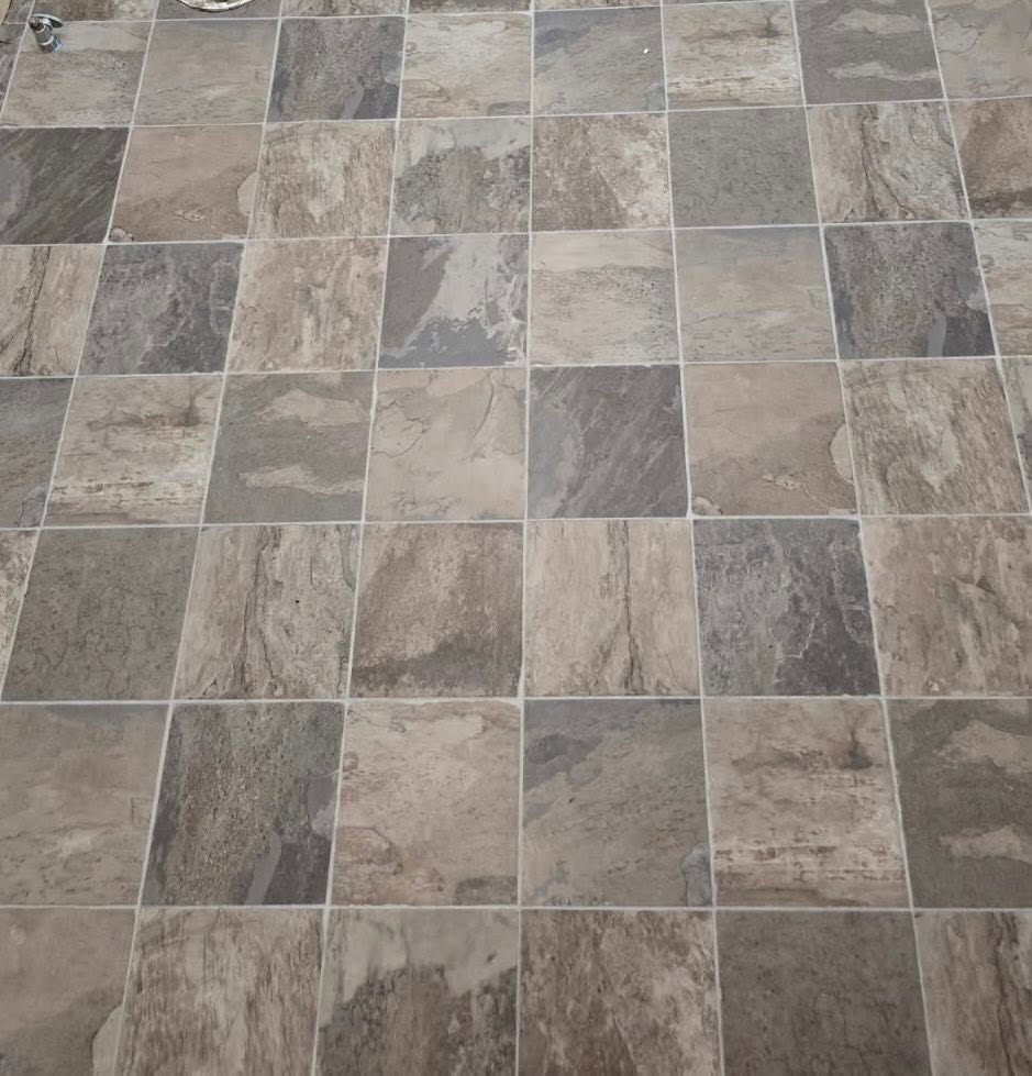 A close-up of gray and beige slate-look tile flooring.