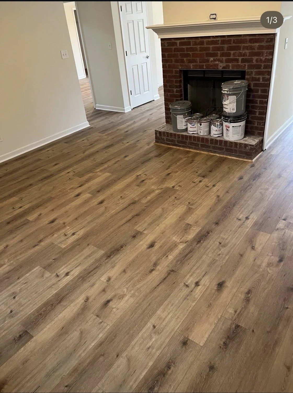 Aerocore Illusion flooring in a living room with a brick fireplace.