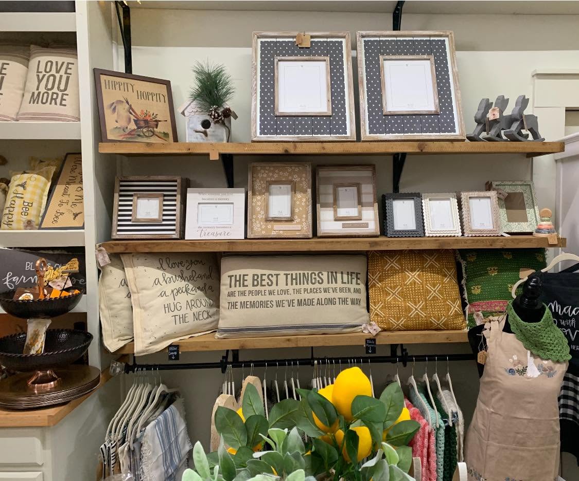 A shelf display of picture frames, throw pillows, and home decor at the Gift Shop.