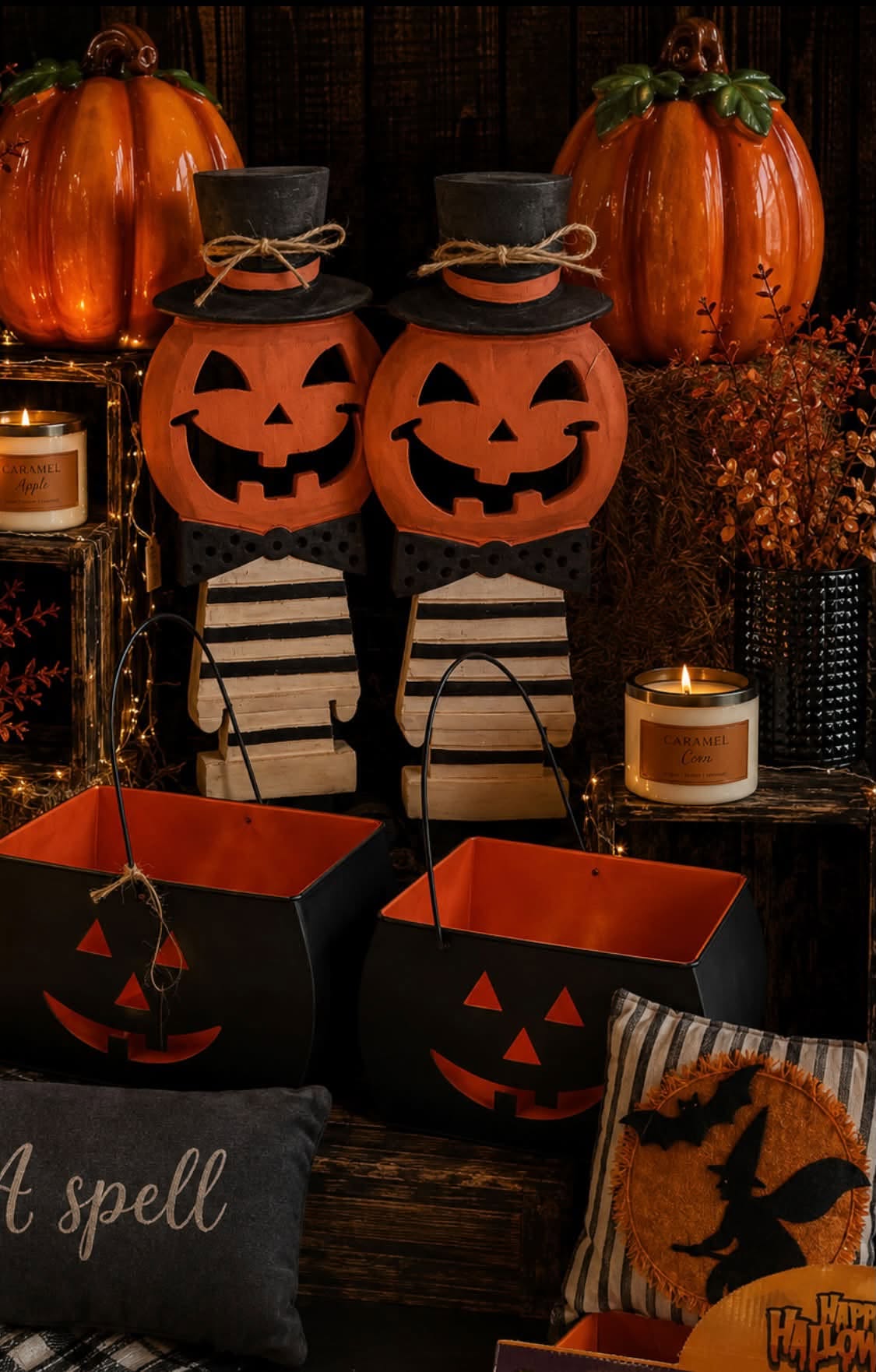 Jack-o-lantern top-hat figures next to black and orange trick-or-treat buckets.