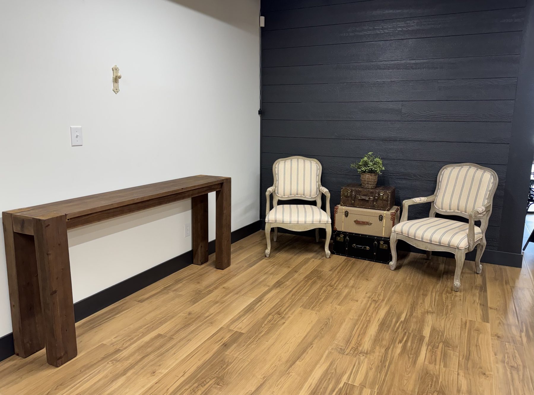 A vintage-styled seating vignette with striped chairs and travel trunks at The Venue.
